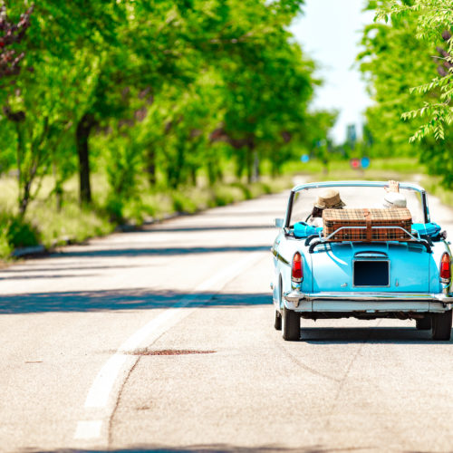 Couple on a road trip with a vintage car