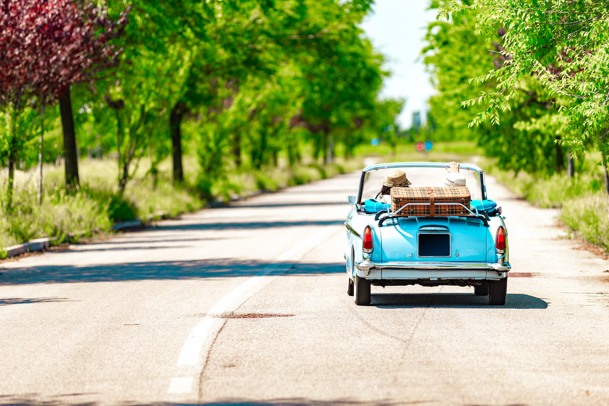 Couple on a road trip with a vintage car