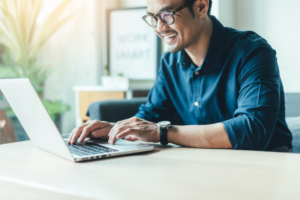 Man smiling while looking at his investment fund performance