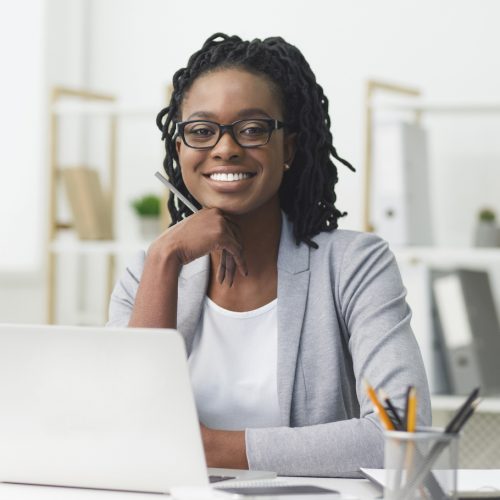 Afro Business Lady Smiling At Camera Sitting At Laptop Women planning retirement